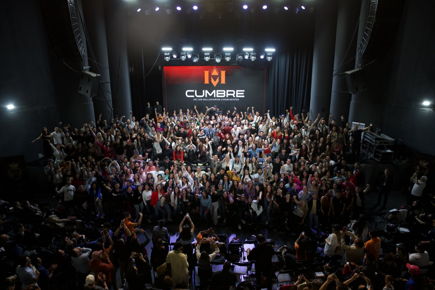 Público de la Cumbre de los Millonarios Conscientes celebrando frente al escenario